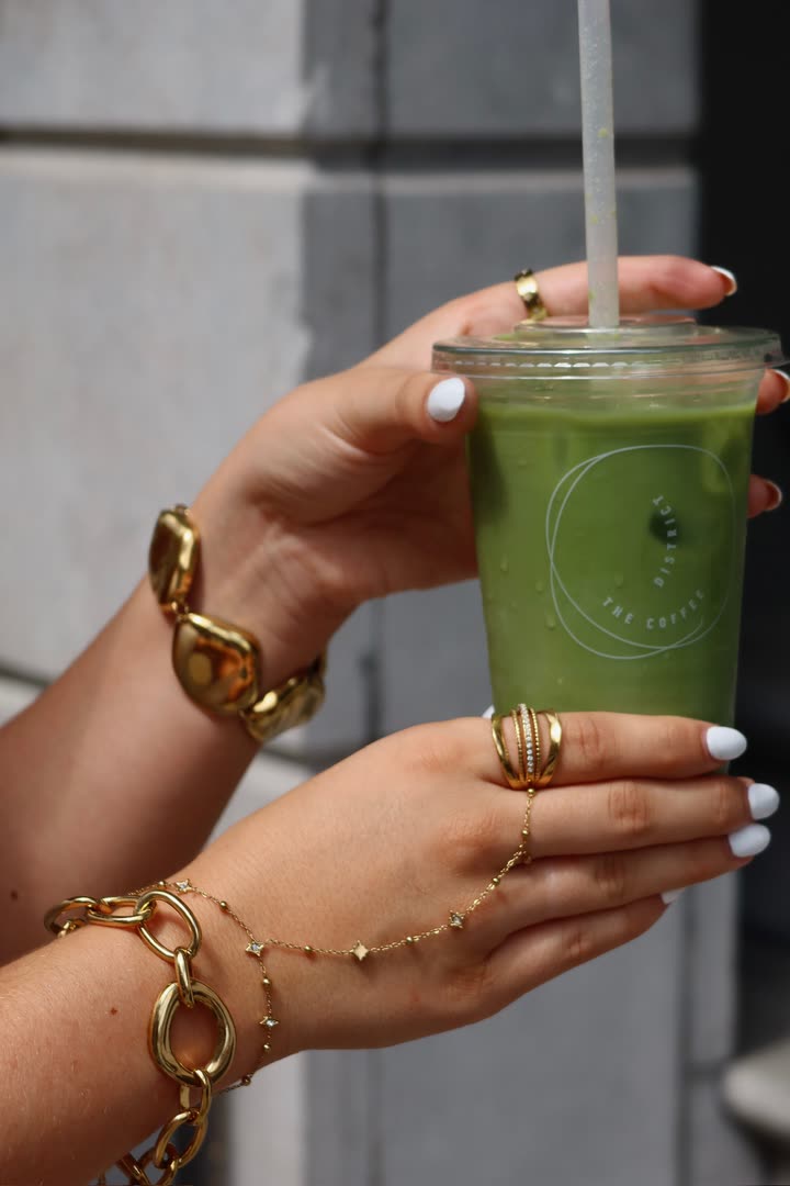 Matcha latte met The Coffee District branding, vastgelegd door Faymous